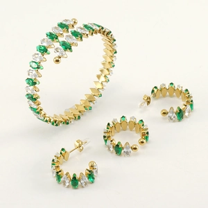 Macro detail of 18K gold stainless steel jewelry set with marquise green gemstones