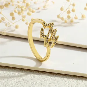Macro shot of gold lightning bolt rings with micro-pave cubic zirconia on white steps