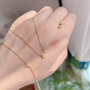 Close-up of 14k gold plated sterling silver clover necklace and earrings set with zircons