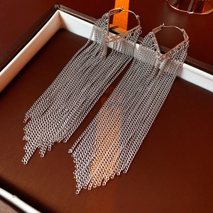 Close-up of silver long tassel earrings with geometric triangle top in a premium gift box