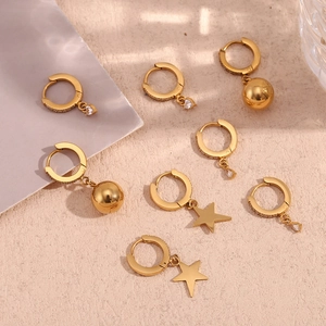 Flat lay of 18K gold plated hoop earrings with star, ball, and zircon charms