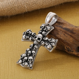 Vintage skull cross pendant in antique silver stainless steel on a rustic wood background