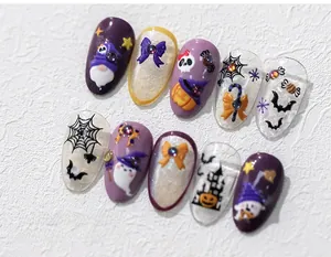 Detail of Halloween press-on nails featuring 3D pumpkin, ghost, and spider web charms