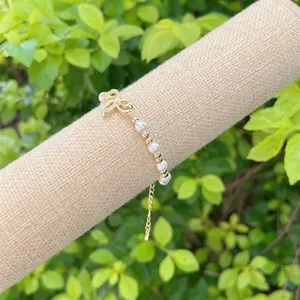 Elegant 18K gold plated bow bracelet with faux pearls and adjustable extension chain