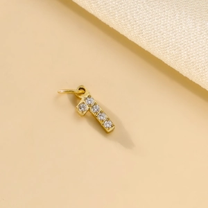 Detailed macro view of a gold-plated number 1 pendant with micro-pave cubic zirconia stones