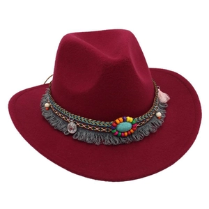 Detail of burgundy felt fedora with turquoise bead, grey tassels, and silver coin pendant