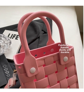 Detailed texture of pink woven EVA beach bag with sturdy handles and white fasteners