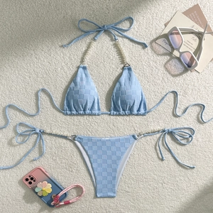 Macro shot of sky blue bikini fabric texture with pearl strap and checkerboard pattern