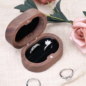 Solid walnut wood double ring box with silver diamond rings on beige linen background