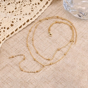Elegant gold layered bead necklace featuring delicate tassels and minimalist Y-shape chain