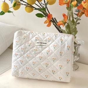 Vue détaillée d'une trousse de maquillage blanche matelassée avec cerises et pois orange