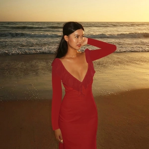 Detail of red deep V-neck dress featuring elegant ruffled trim and a slim fit design