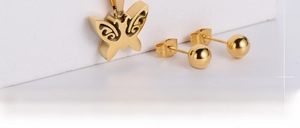 Detailed close-up of a gold-plated titanium steel hollow butterfly pendant and bead earrings