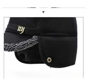 Detail view of winter baseball cap with plush lining, ear flaps and metallic NY logo