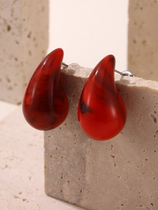 Detailed shot of dark red marble enamel earrings with gold plating on stone base