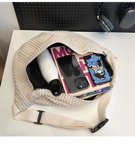 Top view of spacious beige corduroy crossbody bag showing internal capacity with daily items
