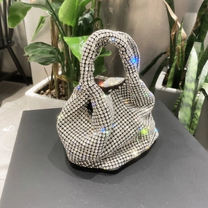 Close-up of sparkling silver rhinestone bucket bag with crystal handle on a display stand