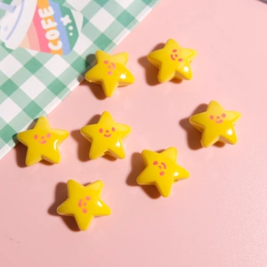 Macro shot of yellow star-shaped resin beads with pink smiley faces for DIY jewelry