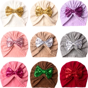 Baby jacquard turban hats in nine colors featuring large sequin bows on white backgrounds