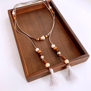 Macro view of bohemian wood bead waist chain with multi-layer fringe tassels and ethnic charms