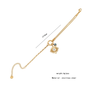 Detailed view of gold stainless steel layered necklace with sun and evil eye charms