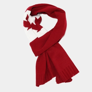 Detail of red knit scarf featuring white maple leaf jacquard and ribbed hem finish