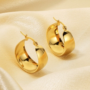 Close-up of 18k gold plated stainless steel wide hoop earrings on silk background