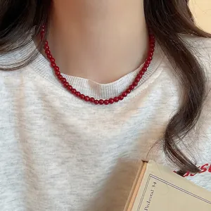 Minimalist bright red glass beaded necklace for women shown on neck model