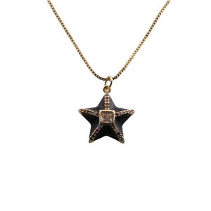Gold star necklace with black star pendant and colorful crystals on white background