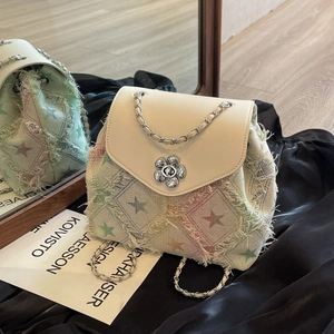 Beige tweed backpack with colorful star pattern, fringe details, and silver chain strap