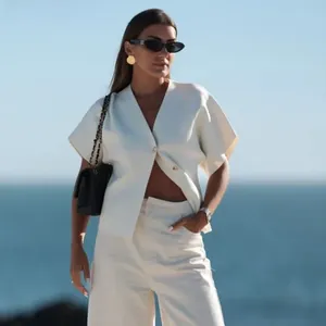 Detail von weißem V-Ausschnitt-Cardigan und Hose mit hoher Taille im Set