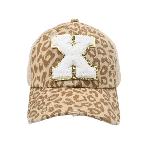 Detail of leopard print ponytail baseball cap with distressed holes and plush letter X