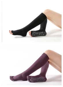 Detail showing non-slip grip soles on black and purple over-knee five-toe yoga socks