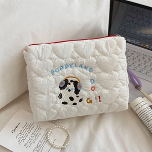 Close-up of white heart quilted makeup bag featuring Dalmatian embroidery and red zipper