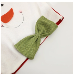 Close-up of plush snowman chair cover decoration with green knit bow and soft texture