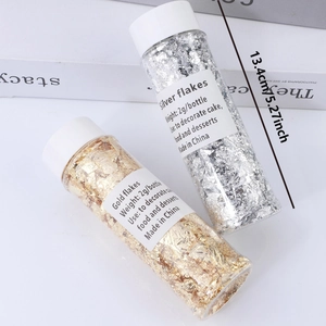 Detail of 2g gold and silver decorative foil flakes in tall bottles for cake topping