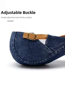 Detail of adjustable brass buckle and brown strap on washed denim beret cap