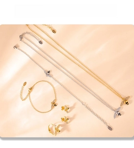 Macro detail of bee-themed jewelry set with PVD plating on elegant beige silk