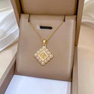 Macro view of luxurious gold cross pendant with pearls and zircons in a jewelry box