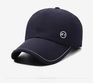 Dettaglio del cappellino blu navy con bordo riflettente della visiera e patch logo KT laterale