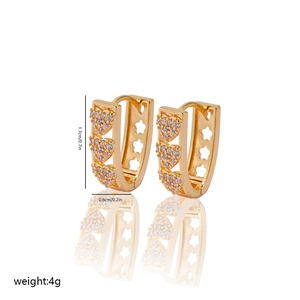 Detail view of gold heart huggie earrings with cubic zirconia and star cutout details