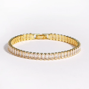 Detailed macro view of gold-plated tennis bracelet with rectangular clear zircon stones