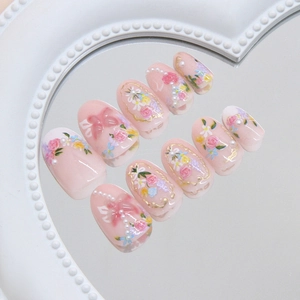 Floral press-on nails with 3D bows and pearls on a heart-shaped mirror tray