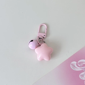 Detailed macro view of pink star charm with a purple bell and painted metal hook