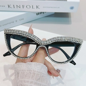 Cat eye sunglasses with black frames and silver rhinestones shown against a fashion book