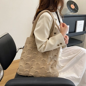 Detail of beige knit tote bag showing soft 3D wavy texture and large capacity shoulder strap