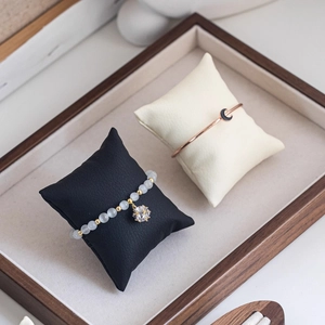Star charm bead bracelet and moon bangle set displayed on jewelry pillows in a wood tray