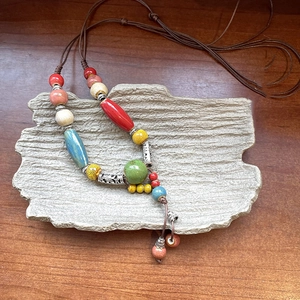 Dettaglio di perle in ceramica vintage e distanziali in metallo argentato su collana intrecciata