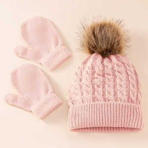Detailed knit texture of pink cable knit winter hat with pompom and matching mittens set