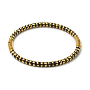 Detailed view of the gold and black striped stainless steel bangle with a secure clasp closure